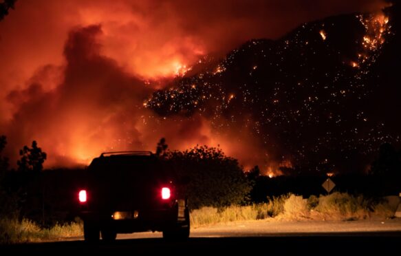 A wildfire burns on the side of the Trans-Canada Highway in British Columbia, Canada.