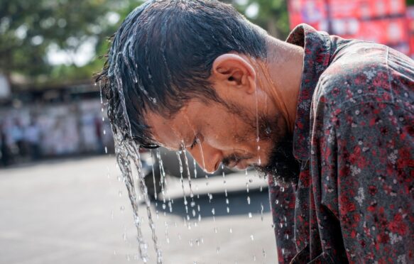 A man bends over during a summer heatwave in Bangladesh.