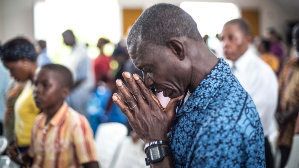 A Christian prays for the people who died due to Ebola, on a ritual in St. Joseph Parish Catholic Church in Monrovia, Liberia on 12 October, 2014.