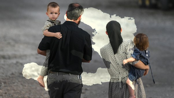 A man and woman hold children as they walk on the grounds of the Christian Aid Ministries headquarters in Titanyen, Haiti on Thursday, Oct. 21, 2021.