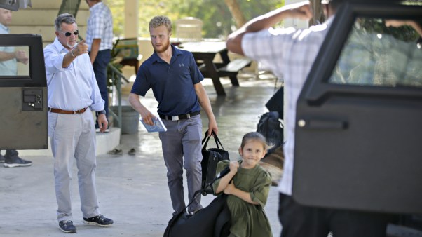 Unidentified people carry bags to a vehicle before departing to the airport from the Christian Aid Ministries headquarters at Titanyen, north of Port-au-Prince, Haiti, on Thursday, December 16, 2021, after 12 hostage missionaries kidnapped two months ago were finally released.