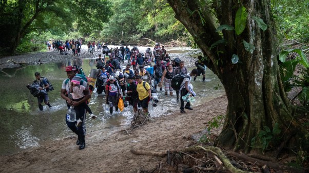 Migrants, most from Haiti, ford one of many rivers they will cross on the trek toward the United States.