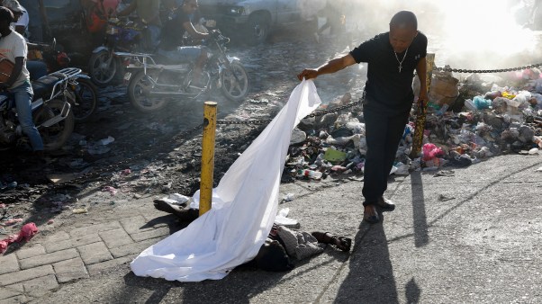 A man identifies a body after an overnight shooting in the Port-au-Prince suburb of Pétion-Ville in March.