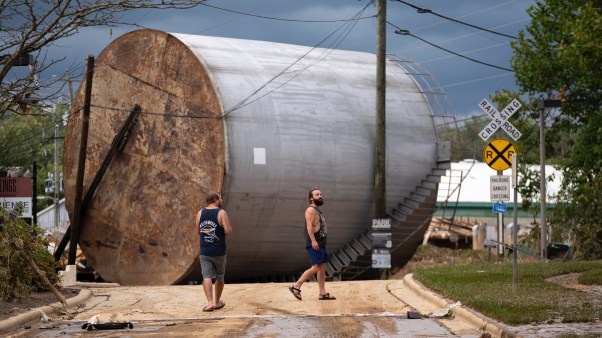 Men inspect damage in the aftermath of Hurricane Helene in Asheville, North Carolina.