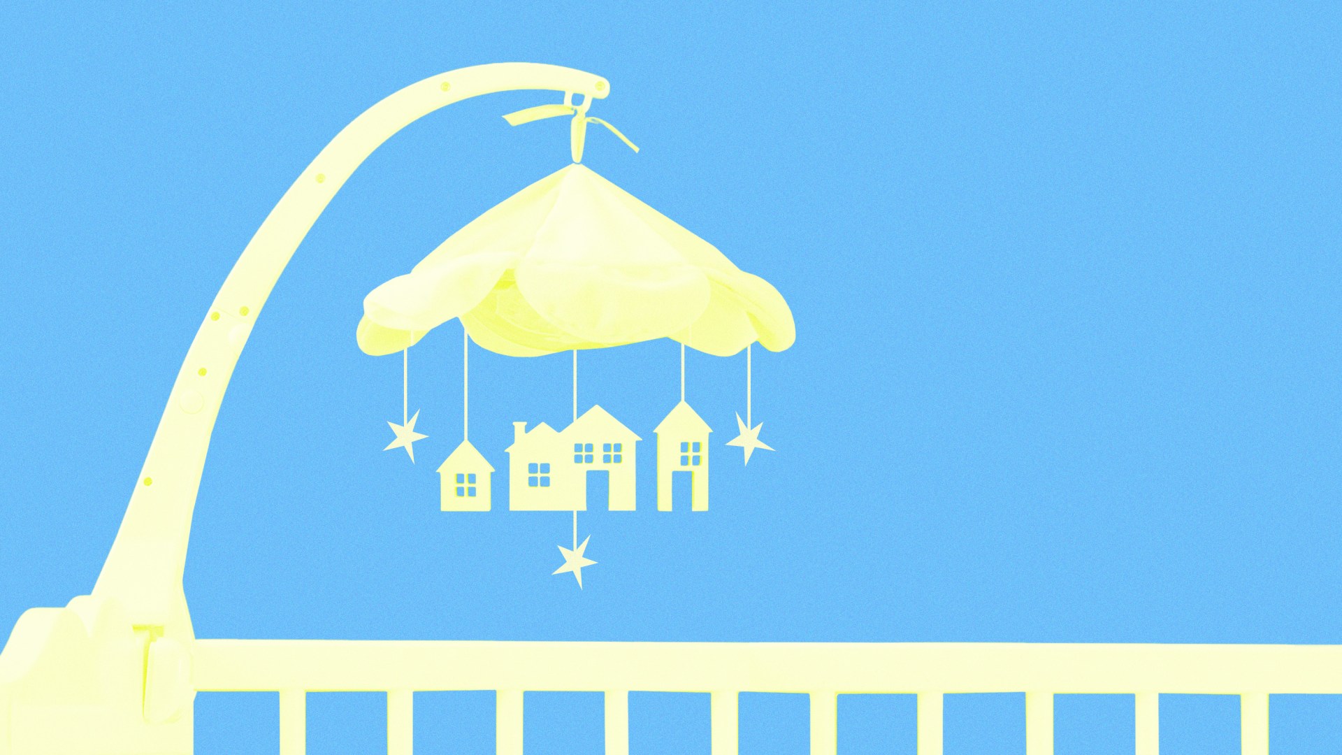 A baby crib mobile with stars and houses hanging from it.