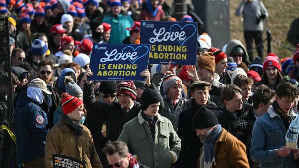 Young marchers hold a sign that says, "Love is ending abortion."