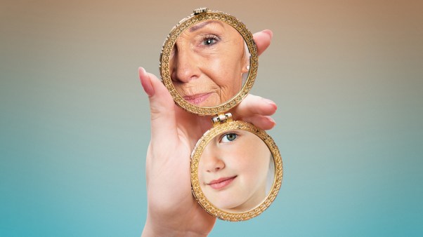 A woman looking at her young and old reflection in the mirror