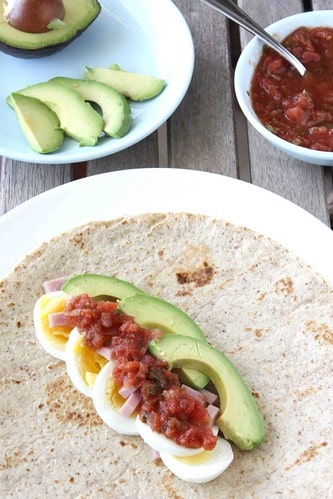 A breakfast wrap topped with salsa.