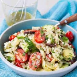 The perfect potluck salad! This easy rice salad recipe has all of the flavors of your favorite Greek salad. 125 calories and 4 Weight Watchers Freestyle SP #salad #rice #healthy #cleaneating