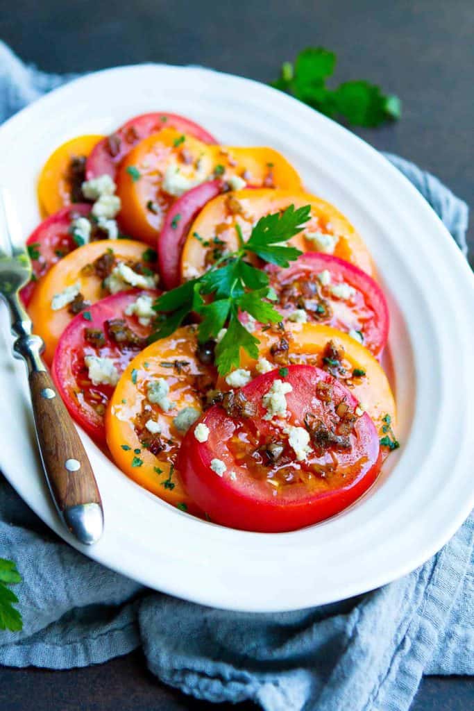 Summertime tomatoes are fantastic on their own, but this Heirloom Tomato Salad is taken to the next level with a light vinaigrette and blue cheese crumbles. 86 calories and 3 Weight Watchers Freestyle SP #tomato #saladrecipes #healthy