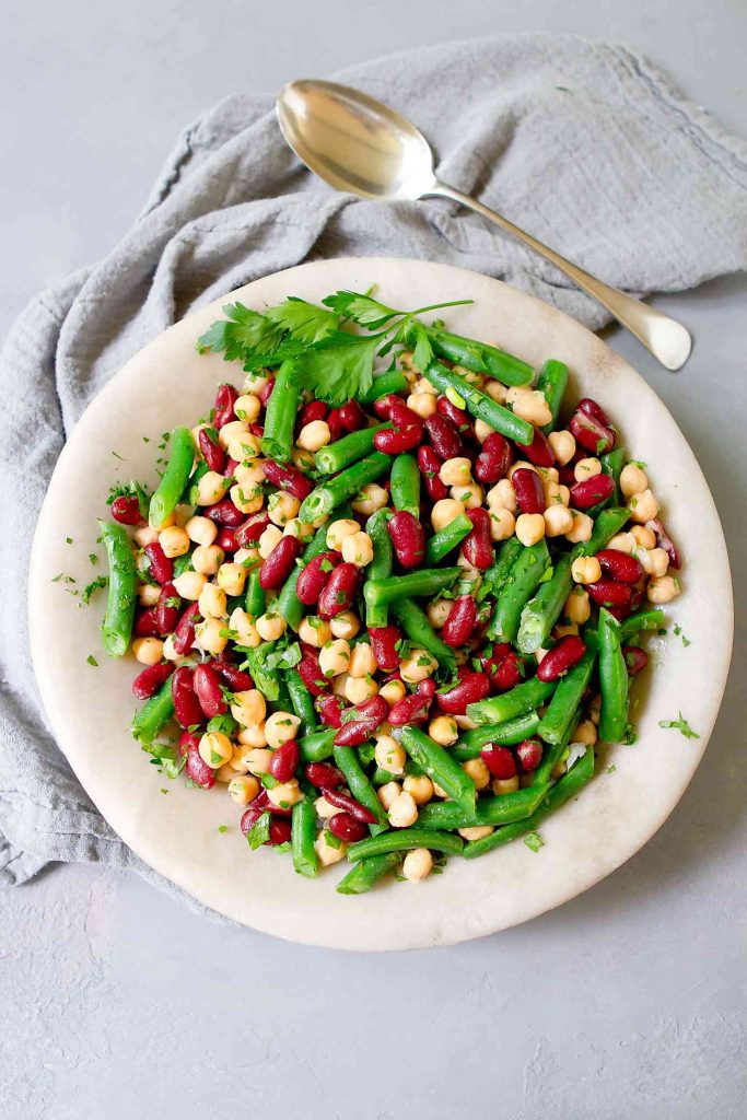 Overhead shot of three bean salad in a light gray stone bowl.