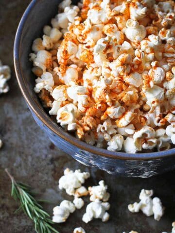 Popcorn topped with paprika olive oil, in a large blue bowl.