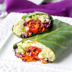 Collard green wraps filled with egg salad and vegetables, on a white plate.