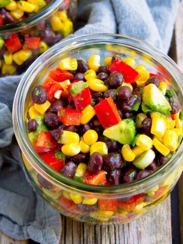 Black bean and corn salad with avocado in a glass jar.