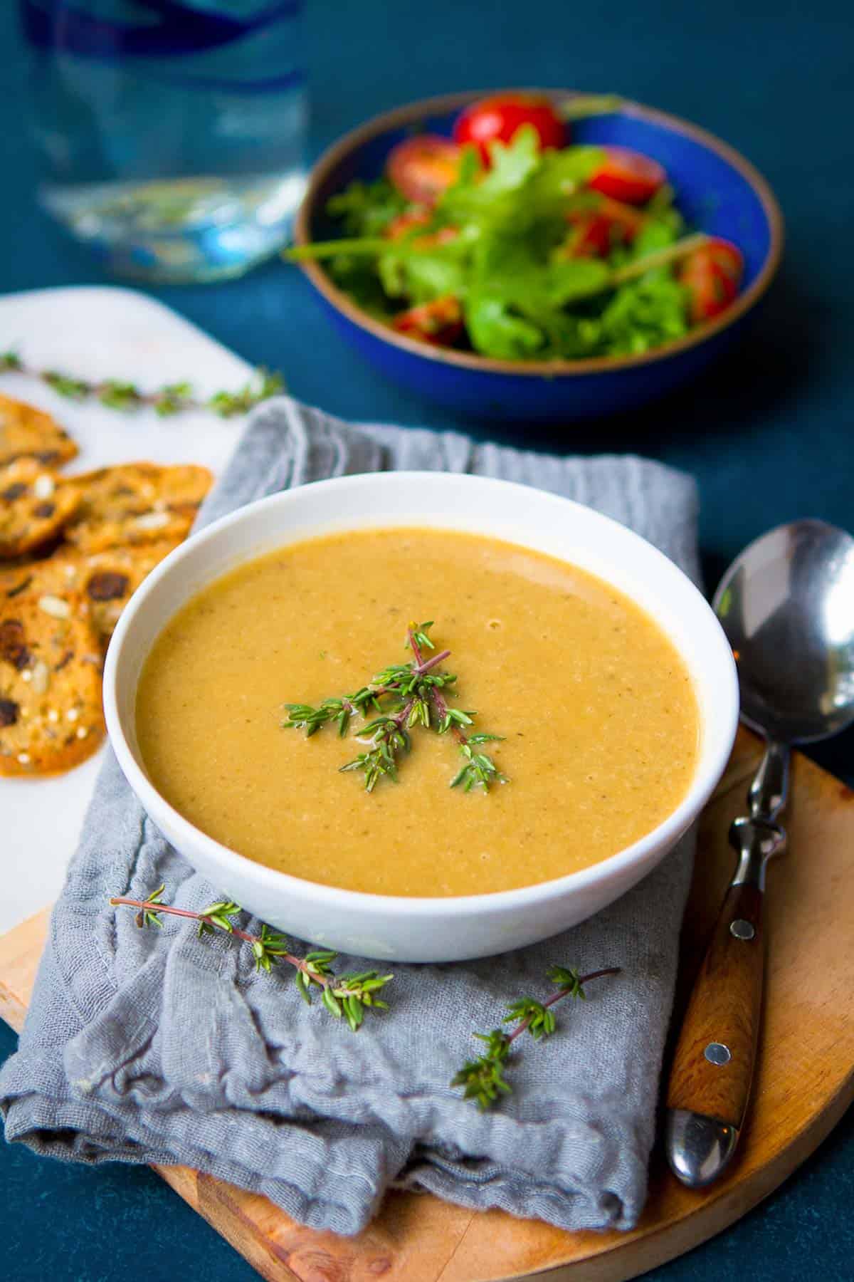 Creamy mushroom soup and thyme spring in a white bowl.