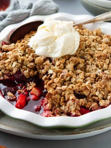 Apple blackberry crumble in a scalloped pie dish.