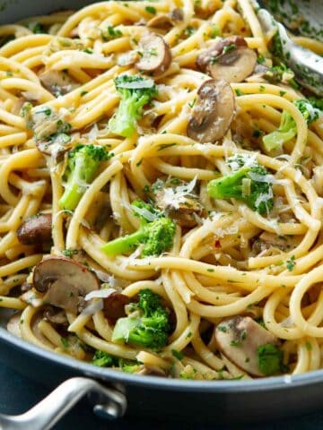 Bucatini pasta with broccoli and mushrooms in a large nonstick skillet.