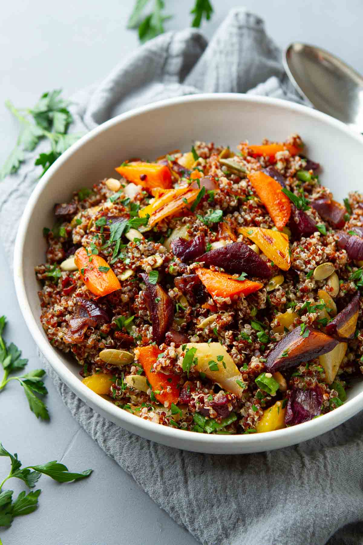 Roasted carrots and onions with quinoa in white bowl.