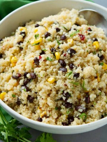 Quinoa salad with black beans and corn in a white bowl.