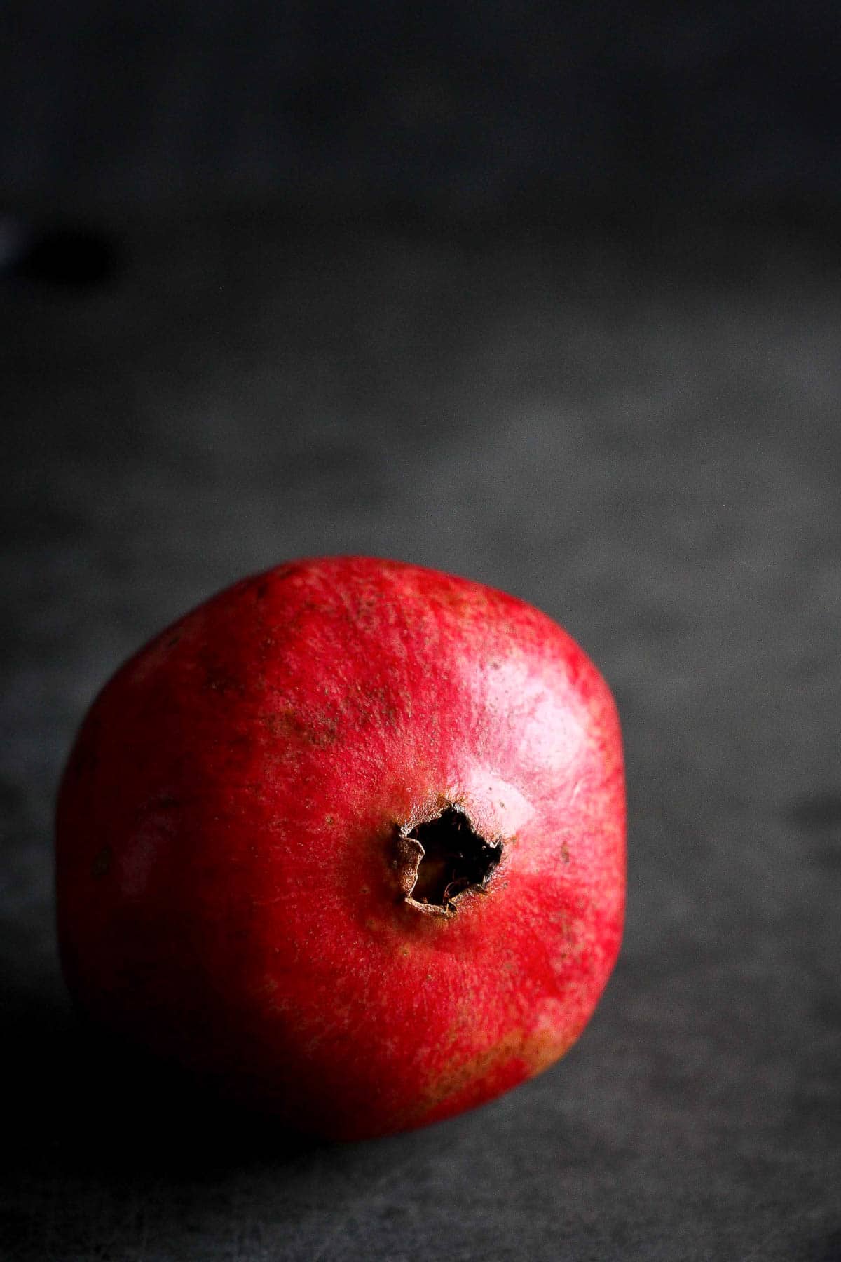 A whole pomegranate on a black background.