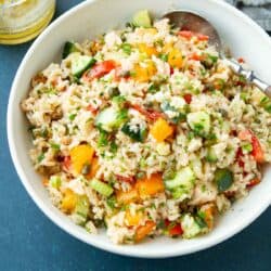 Rice salad with tuna and vegetables in a white bowl.