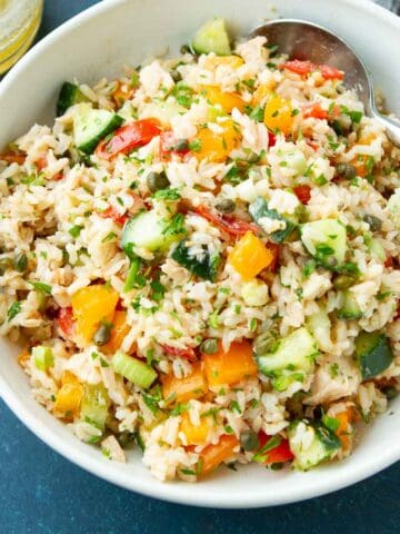 Rice salad with tuna and vegetables in a white bowl.