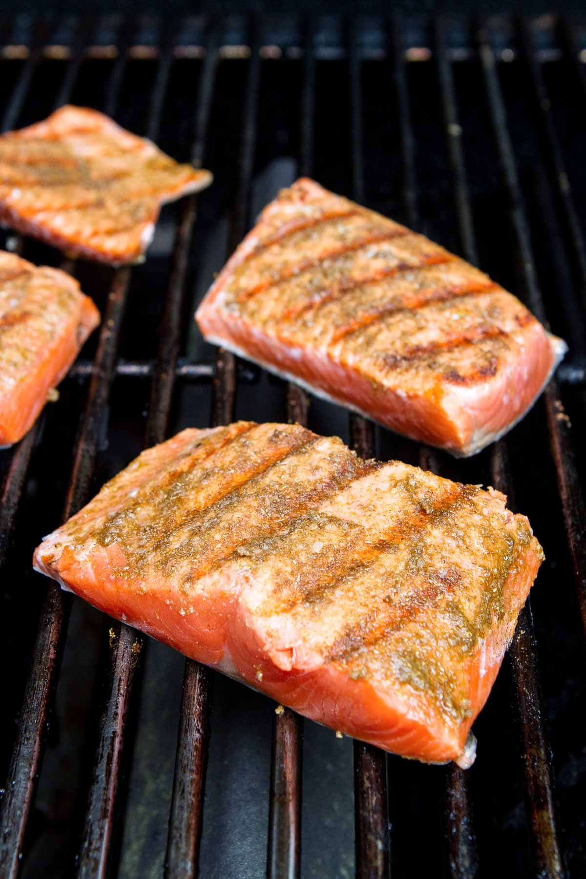 Salmon fillets on the grill, partially cooked.