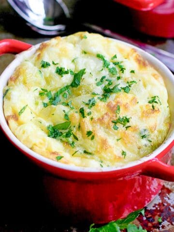 Baked eggs in a red ramekin.