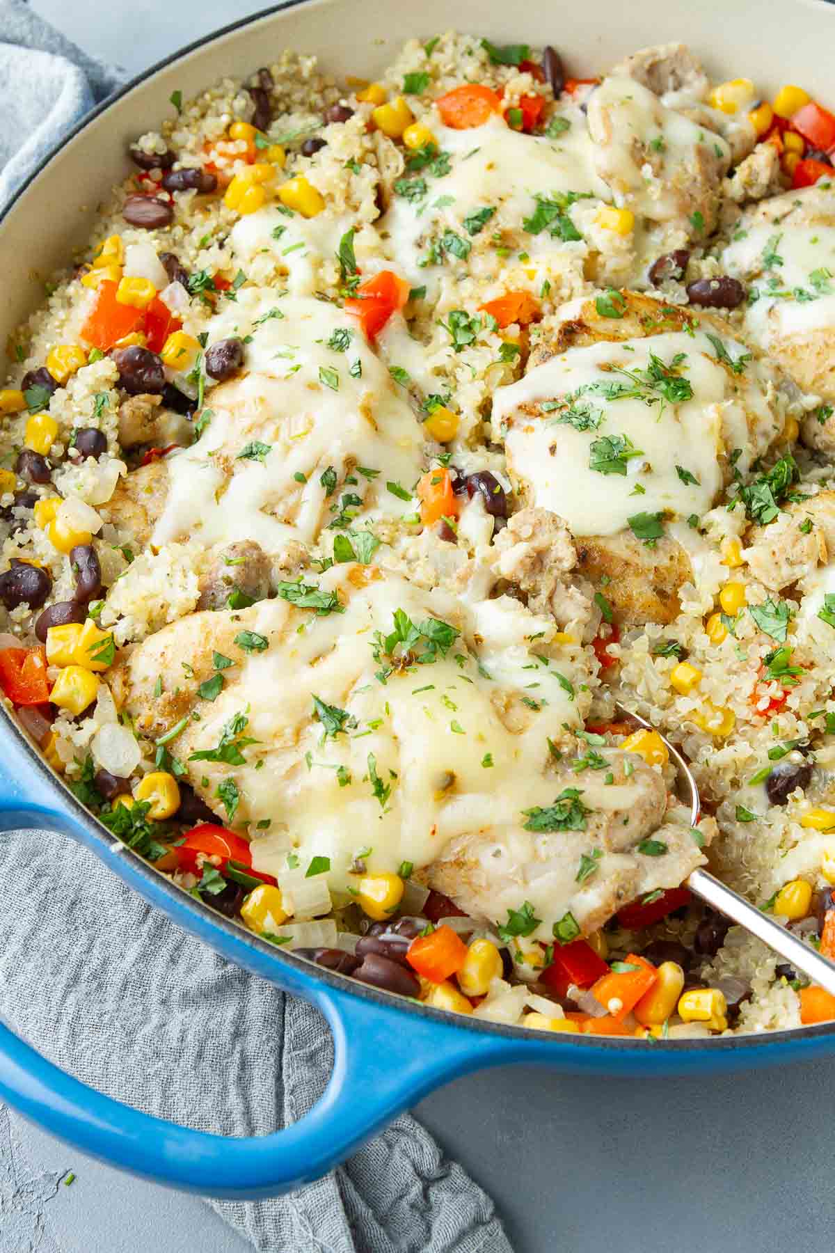 Chicken, quinoa, black beans and corn in a large blue skillet.