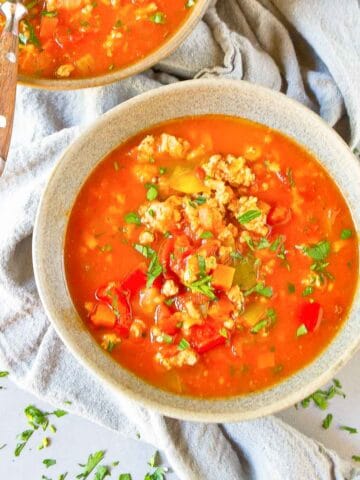 Two bowls filled with stuffed pepper soup, resting on a gray napkin.