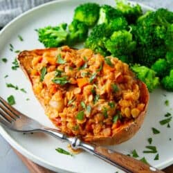 A sweet potato half stuffed with a lentil stew mixture, with broccoli on the side.