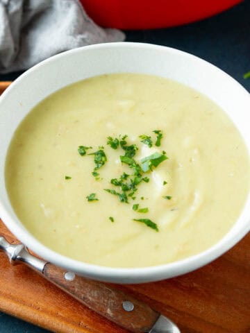 Potato and leek soup in a white bowl.