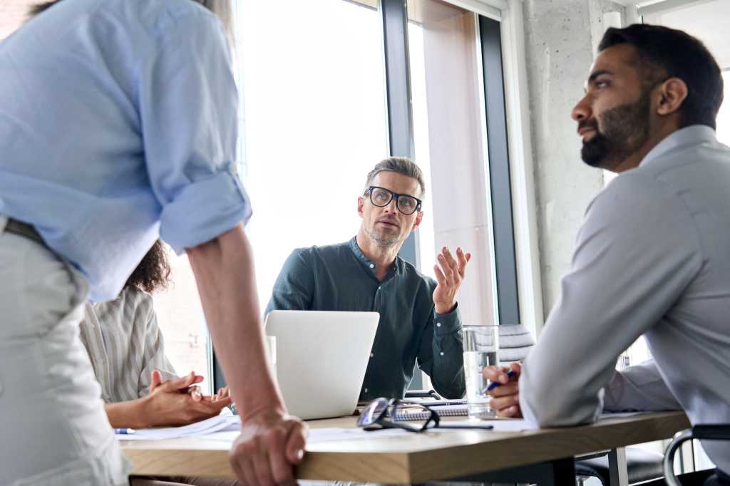 Diverse business people executive team brainstorming sharing ideas with female leader manager at board meeting working in teamwork, discussing company strategy plan during corporate training.