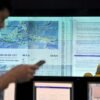 An Indonesian official checks his phone for an SMS earthquake and tsunami warning alert during an Indian Ocean-wide tsunami exercise to test readiness in case of a massive earthquake and tsunami alert