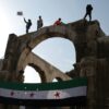 Syrians wave the independence-era flag after midday prayers at the Umayyad Mosque in Damascus on Friday