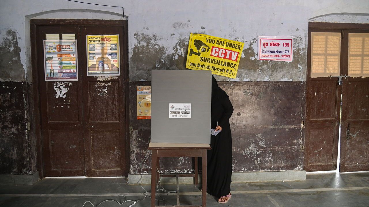 Uttar Pradesh, India: A woman casts her vote on a Electronic Voting Machine (EVM) at a polling station during the fifth phase of the Indian General Elections.