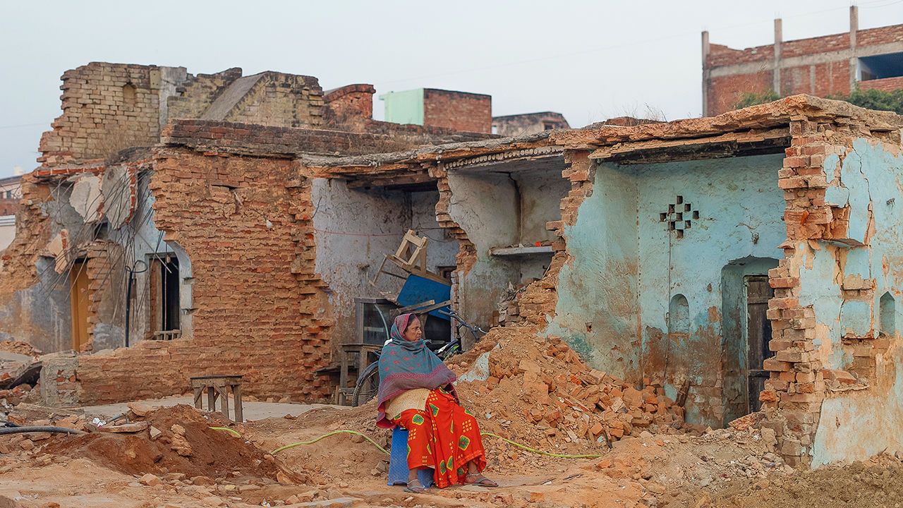 A person sits near outside the houses razed to create a wider road leading to the Ram temple in Ayodhya, India