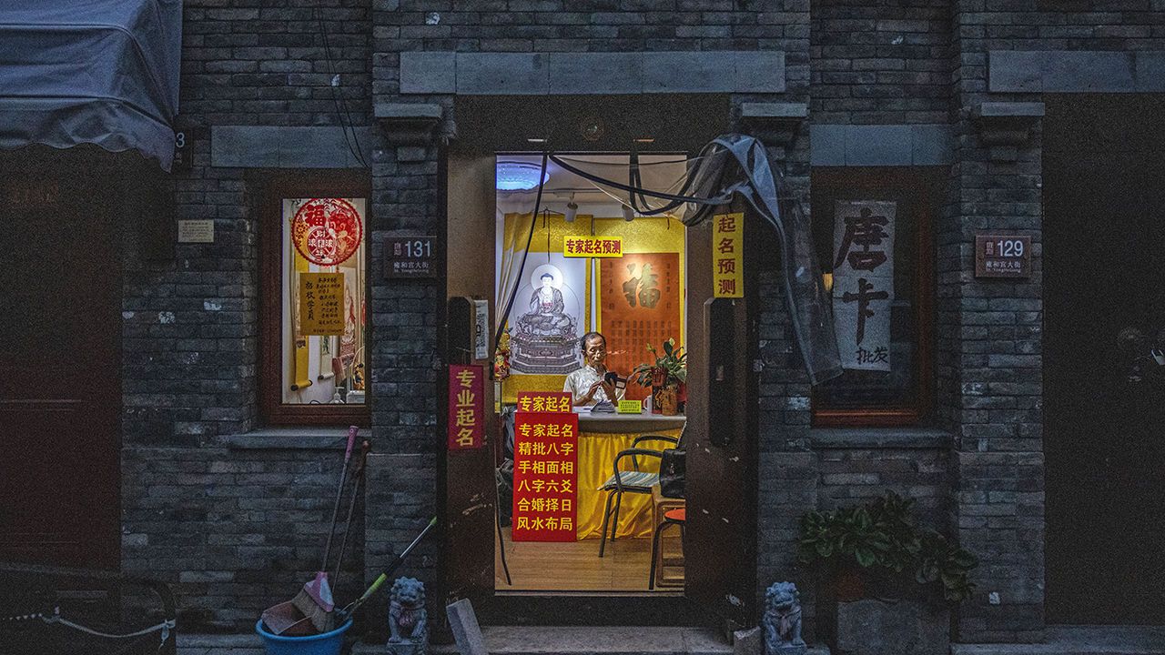 A traditional fortune teller waits for customers in his shop in Beijing, China