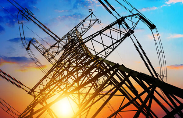 an electricity pylon photographed from underneath with sunlight visible through it