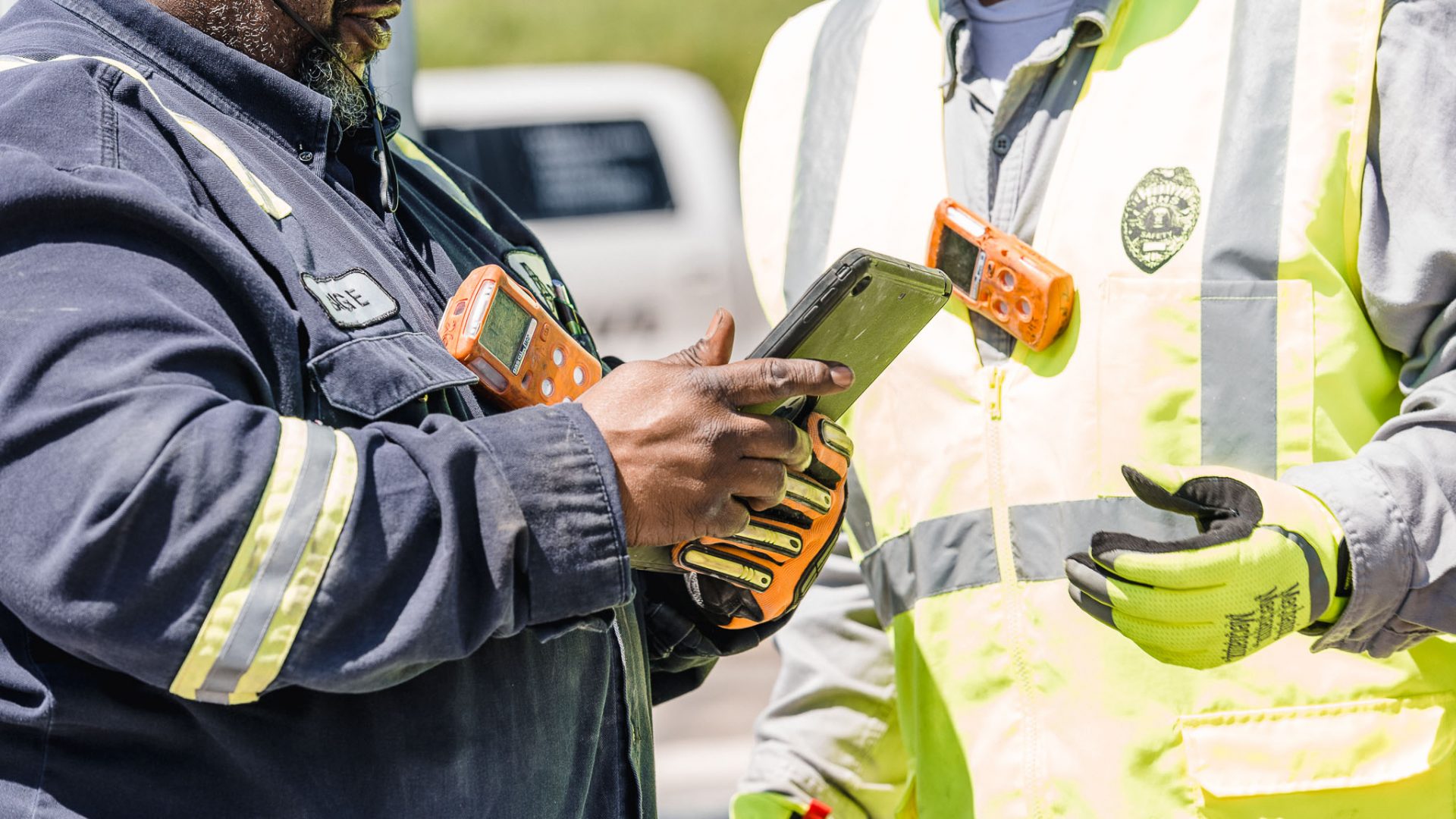 Two people in uniforms looking at an tablet