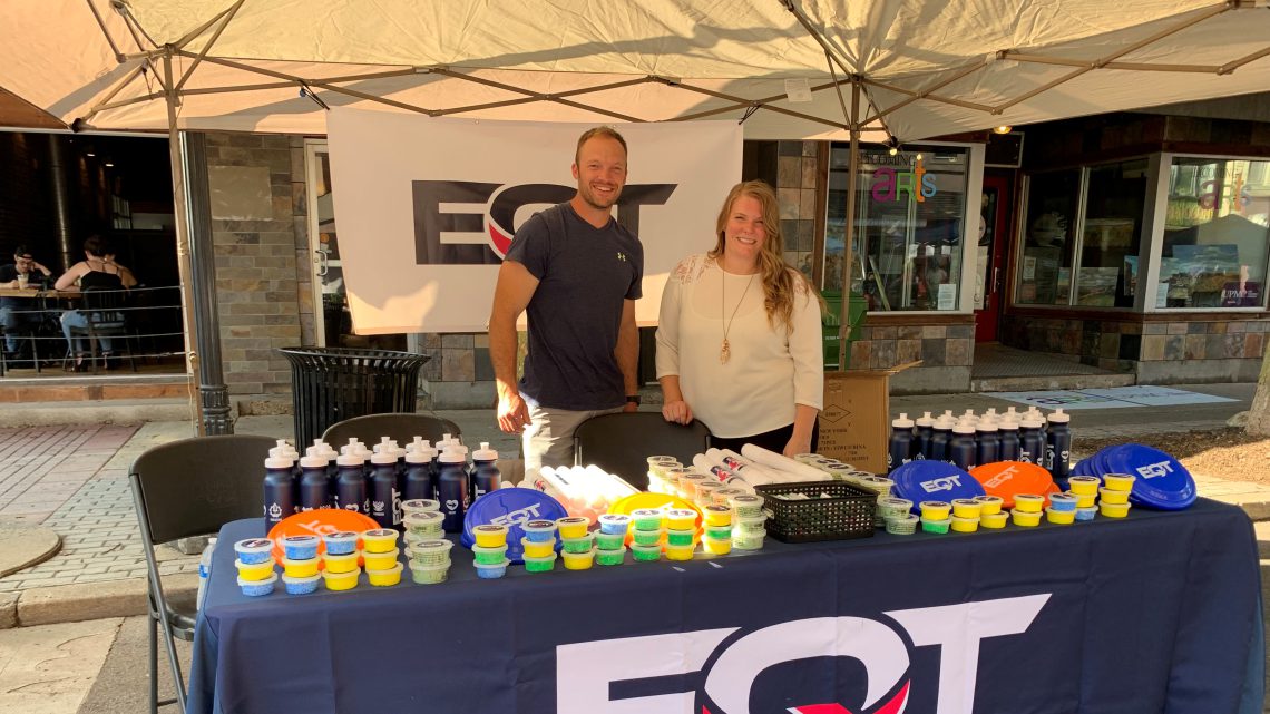 EQT employees talking to people at a event booth