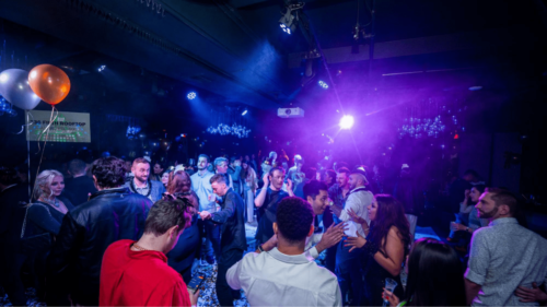 Crowd dances on floor at NYE party