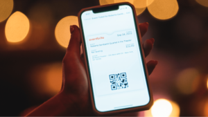 Event attendee holds phone with digital Eventbrite ticket on screen
