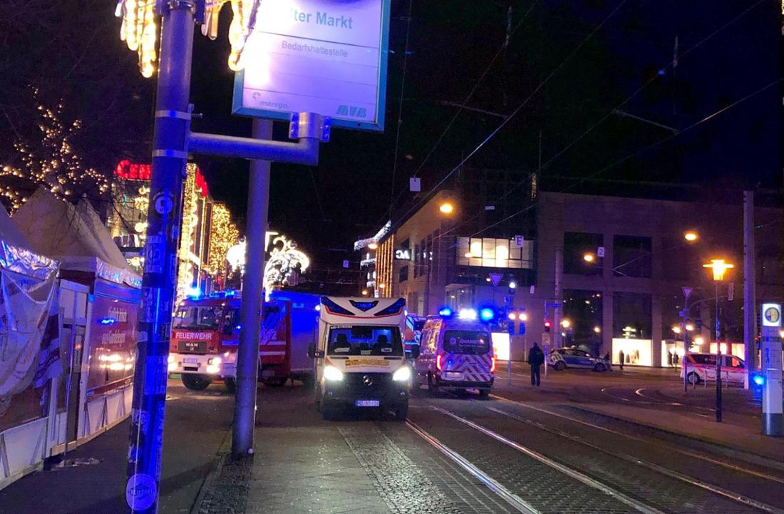 Auf Tram-Schienen stehen in Magdeburg Einsatzfahrzeuge der Rettungsdienste und der Feuerwehr. Sie kümmern sich um die Opfer des Anschlags auf dem Weihnachtsmarkt.