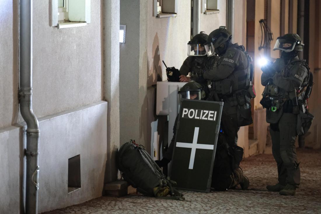 Spezialkräfte der Polizei stehen vor einem Mehrfamilienhaus, das in Zusammenhang mit einer Attacke auf den Weihnachtsmarkt in Magdeburg stehen soll. 