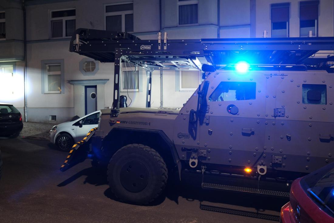 Ein gepanzertes Fahrzeug der Polizei vom Typ „Survivor“ steht vor einem Mehrfamilienhaus, das in Zusammenhang mit dem Anschlag auf den Weihnachtsmarkt in Magdeburg stehen soll. 