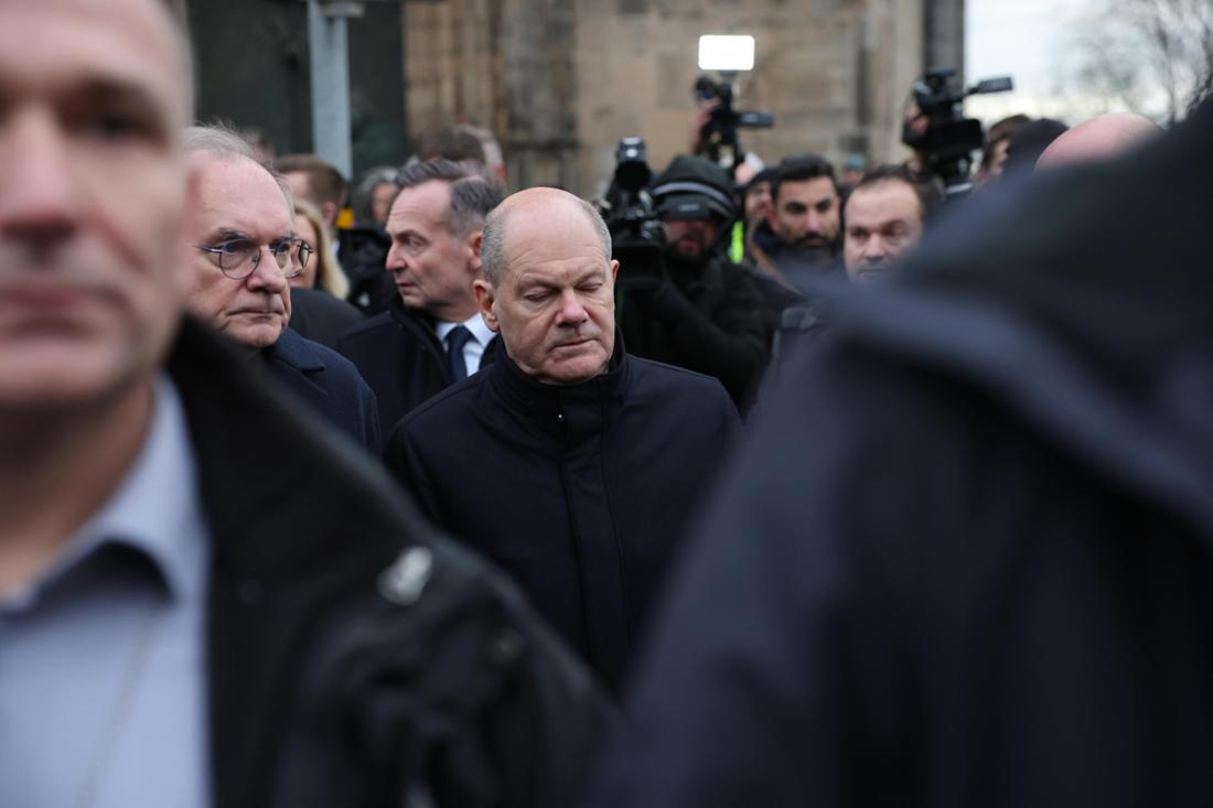 Bundeskanzler Olaf Scholz (Mitte, SPD) und Reiner Haseloff (l, CDU), Ministerpräsident von Sachsen-Anhalt, besuchen den Ort des tödlichen Anschlags auf dem Weihnachtsmarkt in Magdeburg.