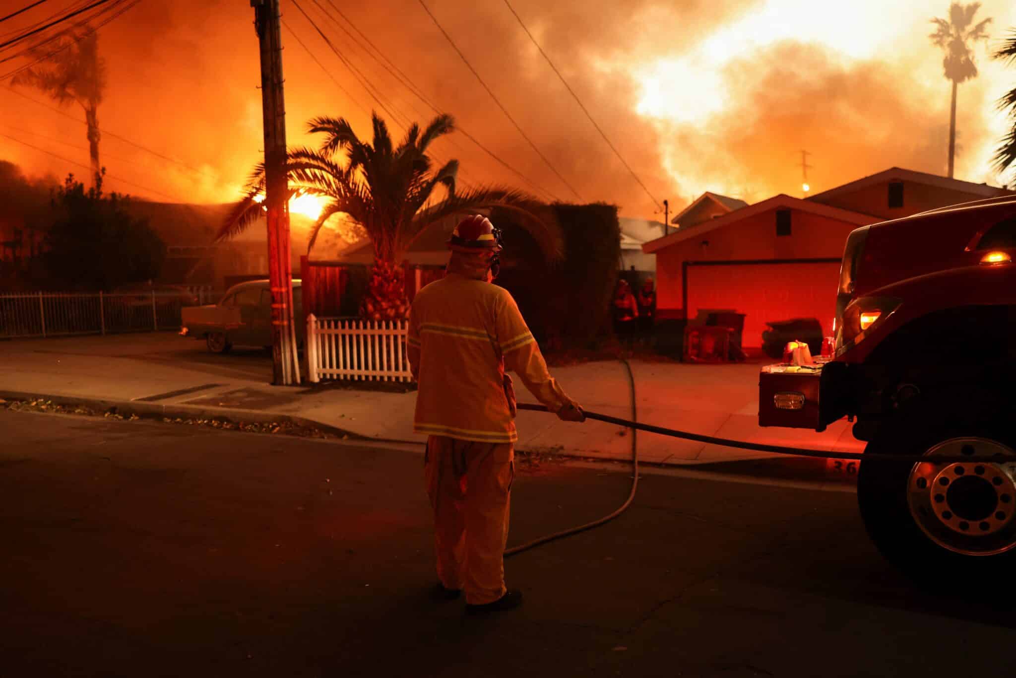 Un bombero trabaja cerca de las casas durante una tormenta de viento en Altadena, California, el 8 de enero de 2025, que alimentó feroces incendios forestales. Los incendios arrasaron la zona de Los Ángeles con una fuerza devastadora el 8 de enero, tras desencadenar una huida desesperada de los residentes de las casas en llamas a través de el fuego, vientos feroces e imponentes nubes de humo. (Foto OSV News/David Swanson, Reuters)