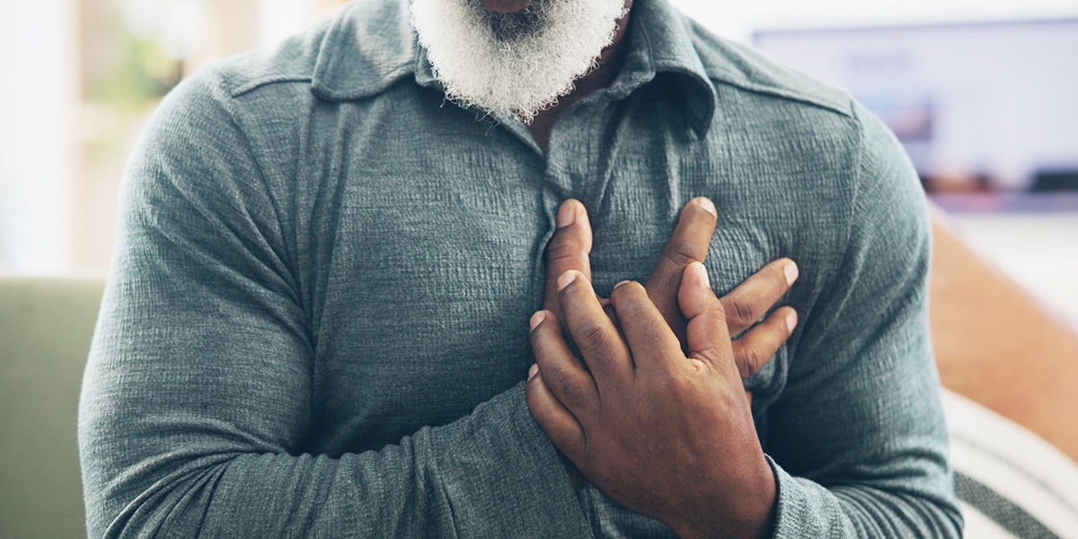 man holding his hands over his heart