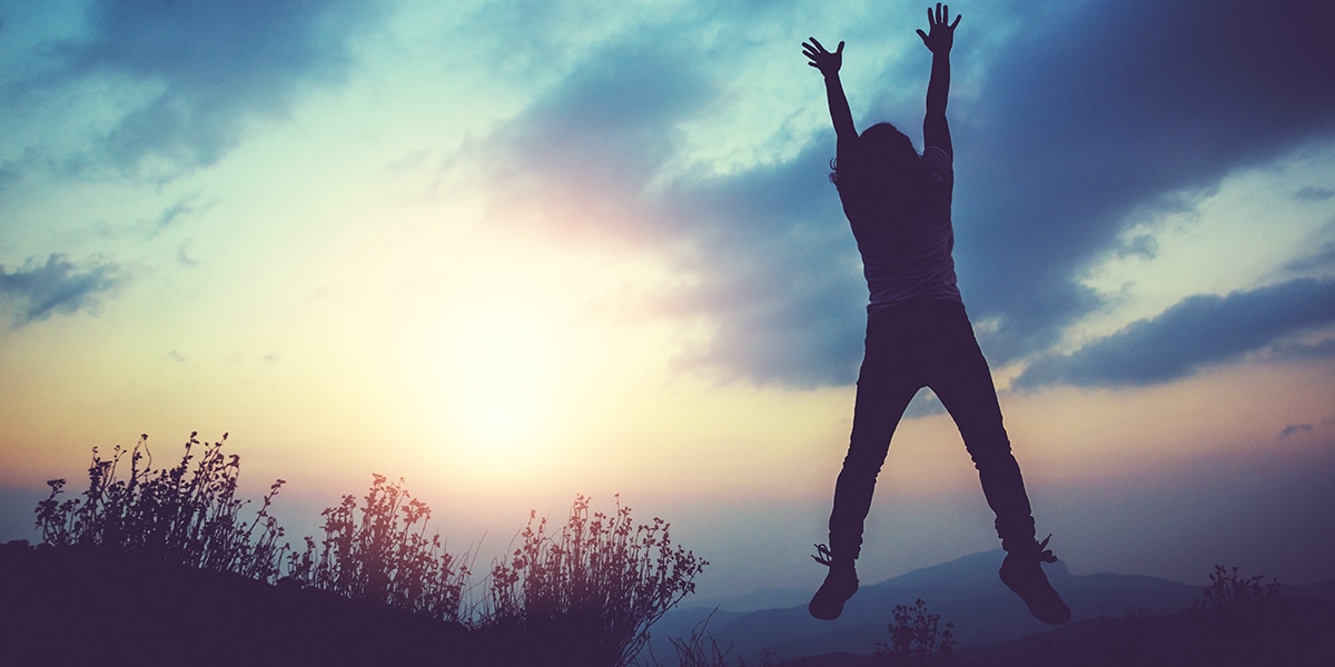 woman jumping and raising her arms, rejoicing